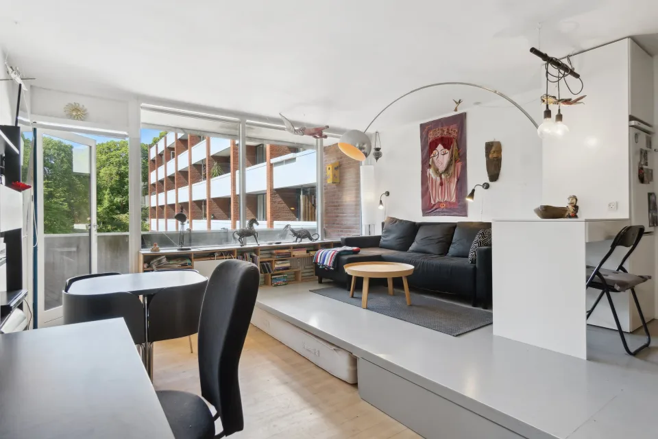 Alrummet før renovering set mod det store vinduesparti med den hævede platform og gulvet i bøg.